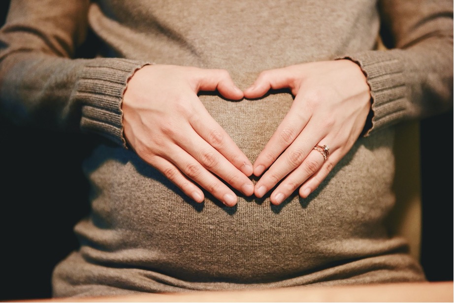 gravid kvinde holder sine hænder på maven